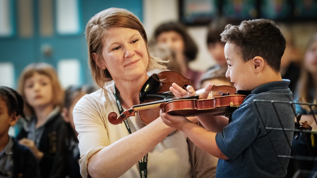 Joyful student and teacher performing in small school concert